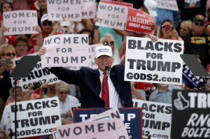 Republican U.S. presidential nominee Donald Trump holds up signs at the end of a campaign rally in Lakeland
